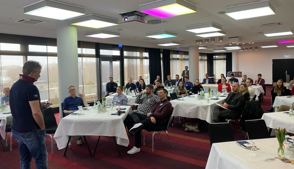 people sitting down at dinner tables in a conference